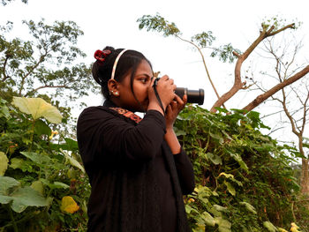 Young woman photographing through camera