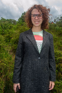 Portrait of smiling young woman standing against plants