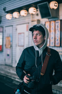 Full length of young man holding camera