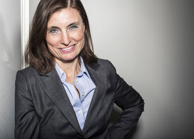 Portrait of mature businesswoman leaning on wall in office