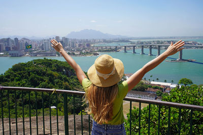 Woman with raised arms enjoying view of vitoria the capital of espirito santo state in brazil