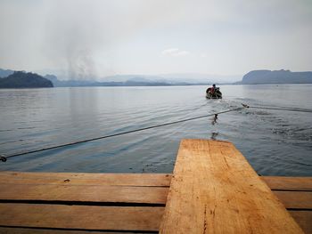 Man fishing on jetty against sea