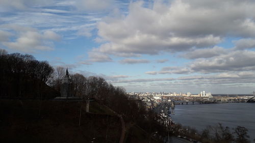 Buildings in city against cloudy sky