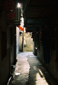 Empty alley amidst buildings in city at night