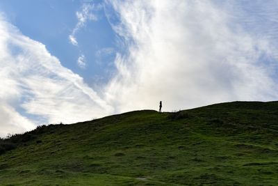 Man on hill against sky
