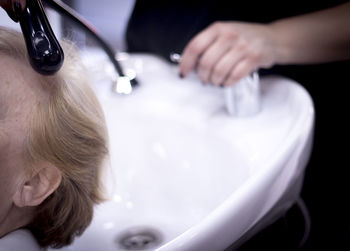Cropped image of woman by sink at hair salon