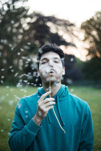 Portrait of young man standing against plants