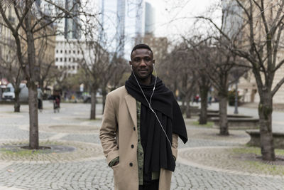 Portrait of man standing on footpath in city