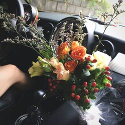 Close-up of hand holding bouquet of flowers