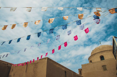 Low angle view of buntings hanging in city against sky