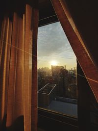 Buildings seen through window during sunset