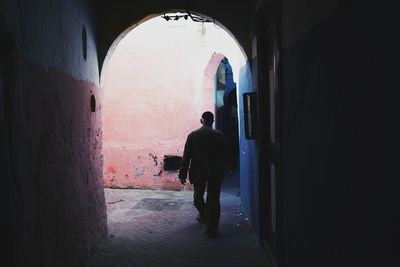 Rear view of man walking in corridor