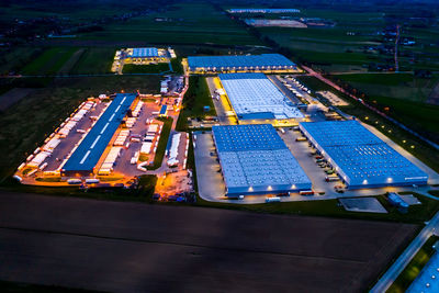 Aerial view of goods warehouse night. logistics center in industrial city zone from above. 