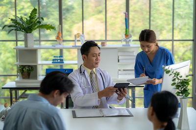 Female friends using digital tablet in office