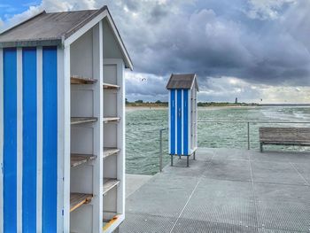 Built structure on beach by sea against sky