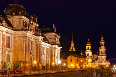 Illuminated buildings in city against sky at night