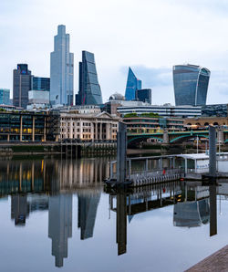 Reflection of buildings in city against sky