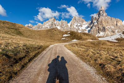 Shadow of man on road against mountain range