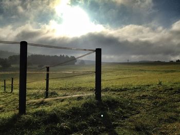 Scenic view of grassy field against cloudy sky