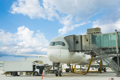 Airplane on airport runway against sky