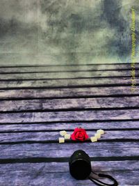 Close-up of red rose on wooden table