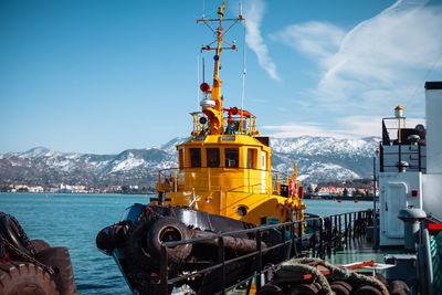 Bright yellow boat in the seaport against the backdrop of mountains