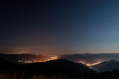 Silhouette mountains against sky at night