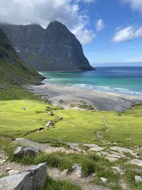 Scenic view of beach and mountains against sky in lofoten