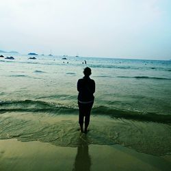 Rear view of woman standing on beach