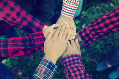 Close-up of friends stacking hands in park