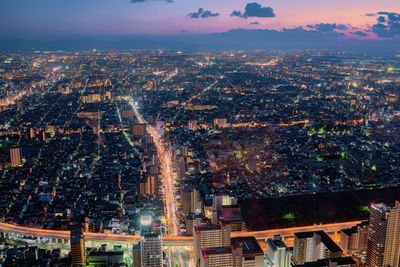 High angle view of illuminated city buildings against sky