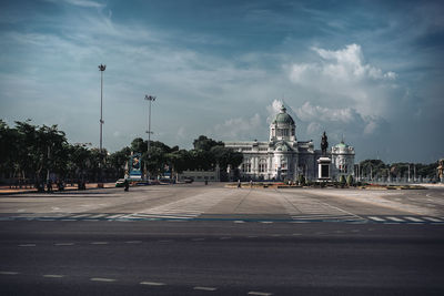 View of city street against cloudy sky