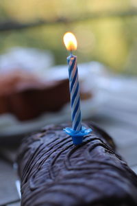 Close-up of burning candle against black background