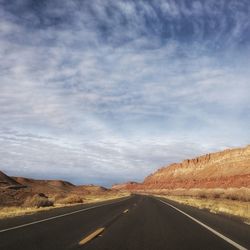 Empty road along countryside landscape