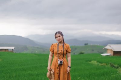 Woman standing on field against sky