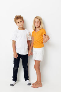 Portrait of smiling boy standing against white background