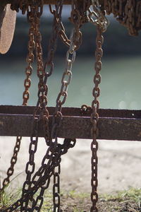 Close-up of chain on railing against sky