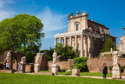 Tourists visiting the ancient ruins of the house of the vestal virgins at the roman forum in rome