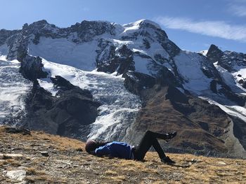 Person on snowcapped mountain against sky