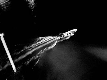 Close-up of hand holding umbrella over black background