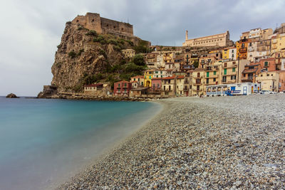 Buildings by sea against sky in city