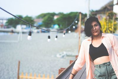 Young woman standing by railing