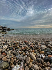 View of pebbles on beach against sky