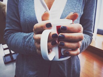 Close-up of human hand holding coffee cup