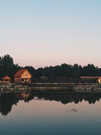 Reflection of building in lake against clear sky