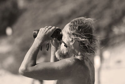 Side view of senior man looking through binoculars