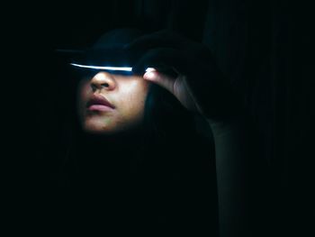 Close-up portrait of a woman in darkroom