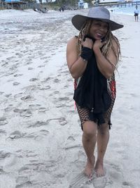 Portrait of beautiful young woman standing on beach