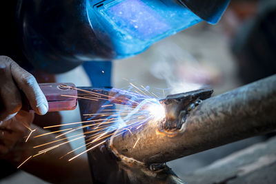 Cropped image of person working on metal