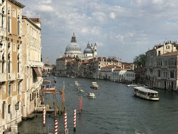 Boats in canal amidst buildings in city